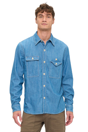 Man wearing a blue chambray shirt on a white background.
