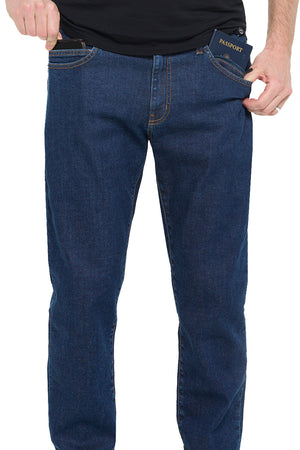 Model with a phone and passport in his Aviator Fly One Travel Jeans.