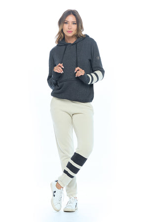 Female model wearing the first class lounge set with travel hoodie and sand color travel pants.