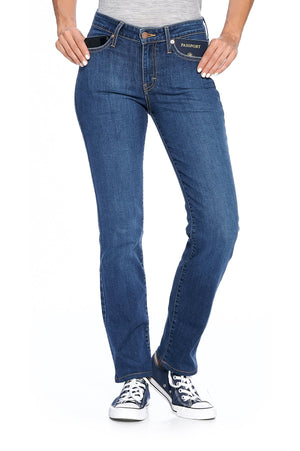 Model posing wearing fly straight women's travel jeans in medium indigo color.