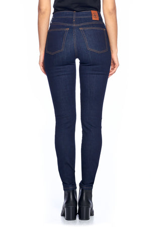 Back view of Aviator dark indigo skinny travel jeans with boots