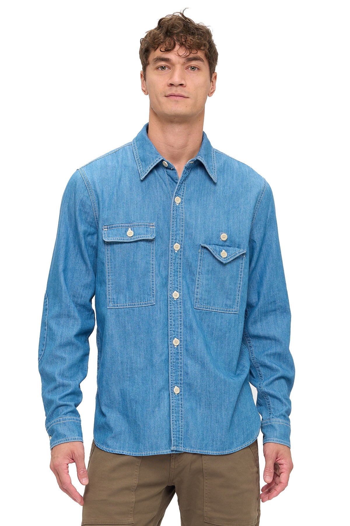 Man wearing a blue chambray shirt on a white background.