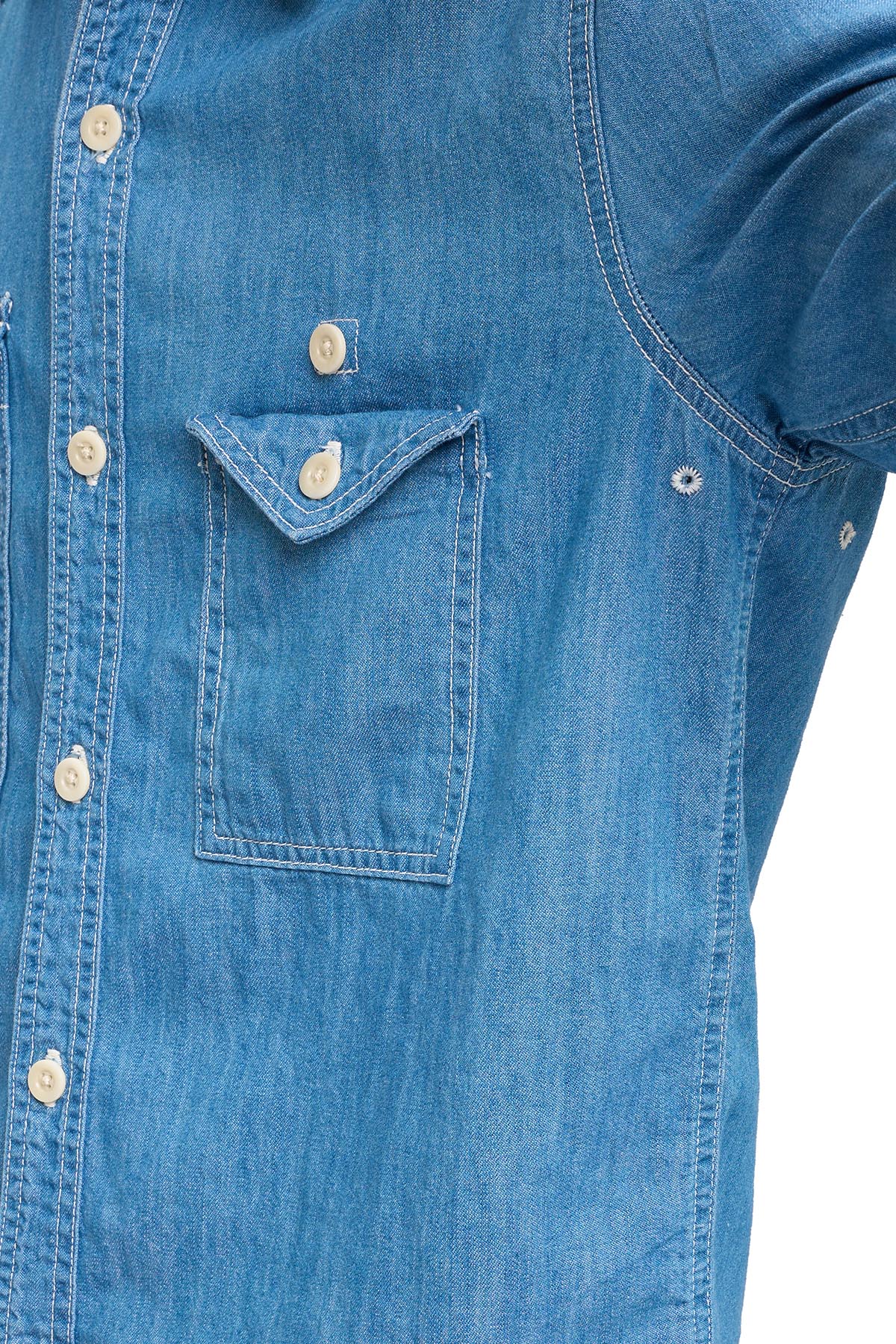 Close-up of a blue chambray shirt showing air vents in armpit, on a white background