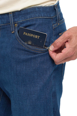 Passport being placed into the front security pocket of men's vintage indigo travel jeans