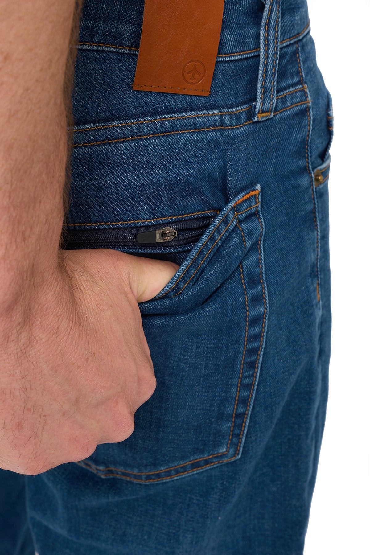 Hand opening the hidden zipper back pocket on men's vintage indigo tailored travel jeans