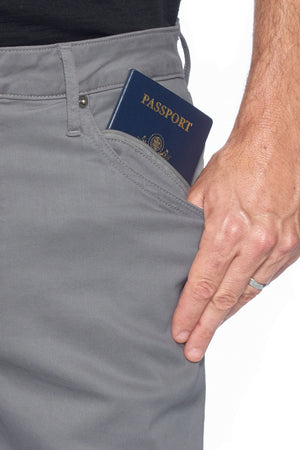 Man using the hidden zipper pocket on Aviator's vintage dark steel pickpocket proof pants.