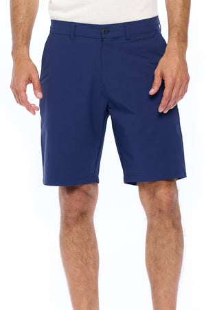 Close up of model wearing the non stop travel shorts 3.0 in navy blue.
